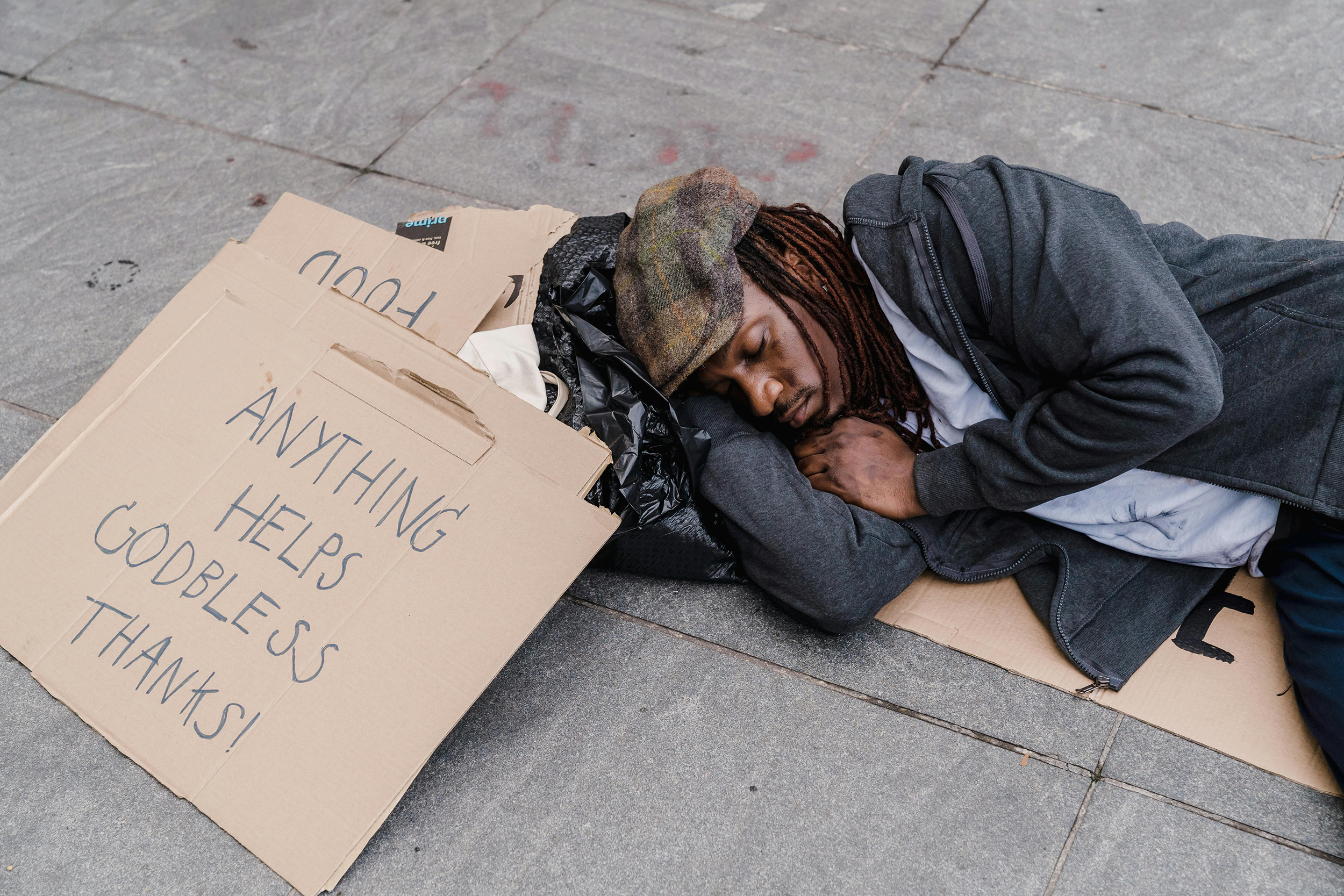 homeless man sleeping with cardboard